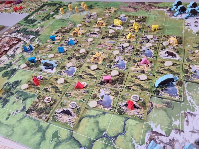 Vue du plateau central de Doggerland en pleine partie : tuiles de terrain, meeples colorés, mammouths et rennes